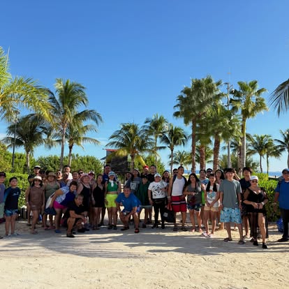 Grupo de viajeros de Excursiones JAWAR reunido junto a palmeras y la playa